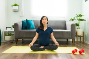 Pregnant woman in seated butterfly prenatal yoga pose to open hips